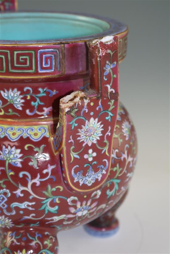 A Chinese famille rose ruby ground tripod censer, Jiaqing six character seal mark and of the period (1796-1820), height 27cm, damage an